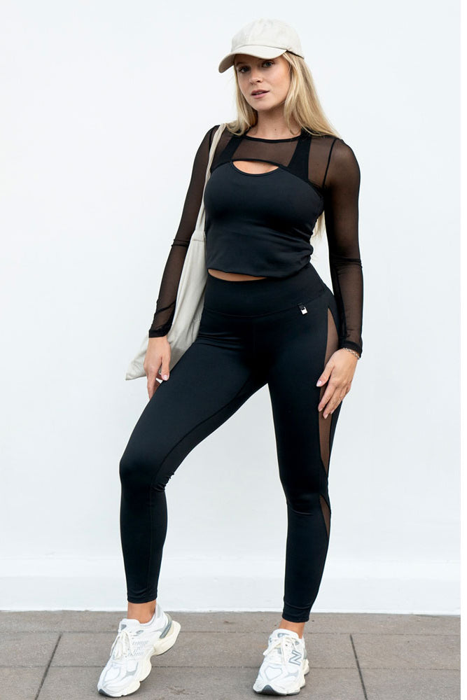 Bij de legging worden een zwarte top met meshmouwen, een pet en een witte katoenen tas gedragen.