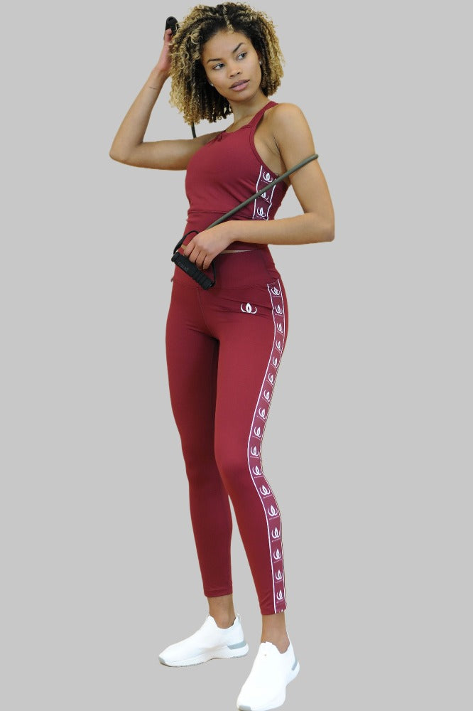 Met een springtouw in de hand wordt de wijnrode legging gedragen bij een croptop in dezelfde kleur.