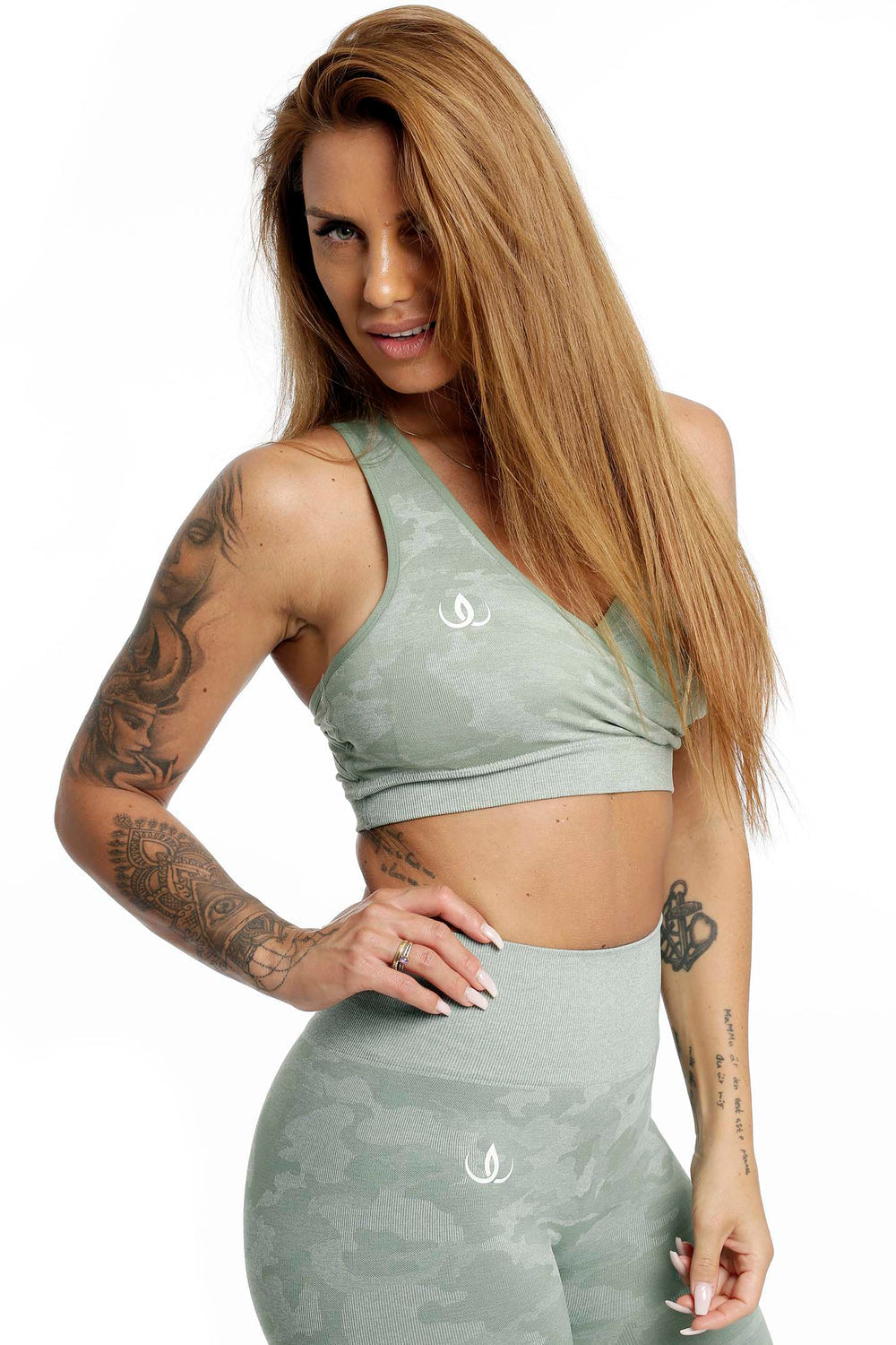 Wit logo op de mintgroene top die nauw over de taille aansluit, legging in hetzelfde patroon.