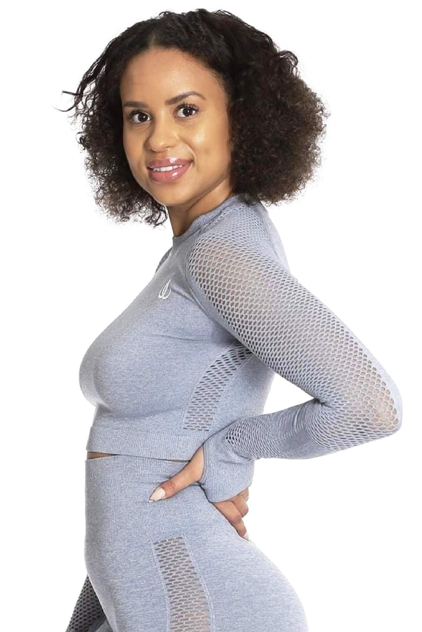 Het meshgedeelte op de mouw is duidelijk zichtbaar wanneer het model zich draait in de grijze trui.