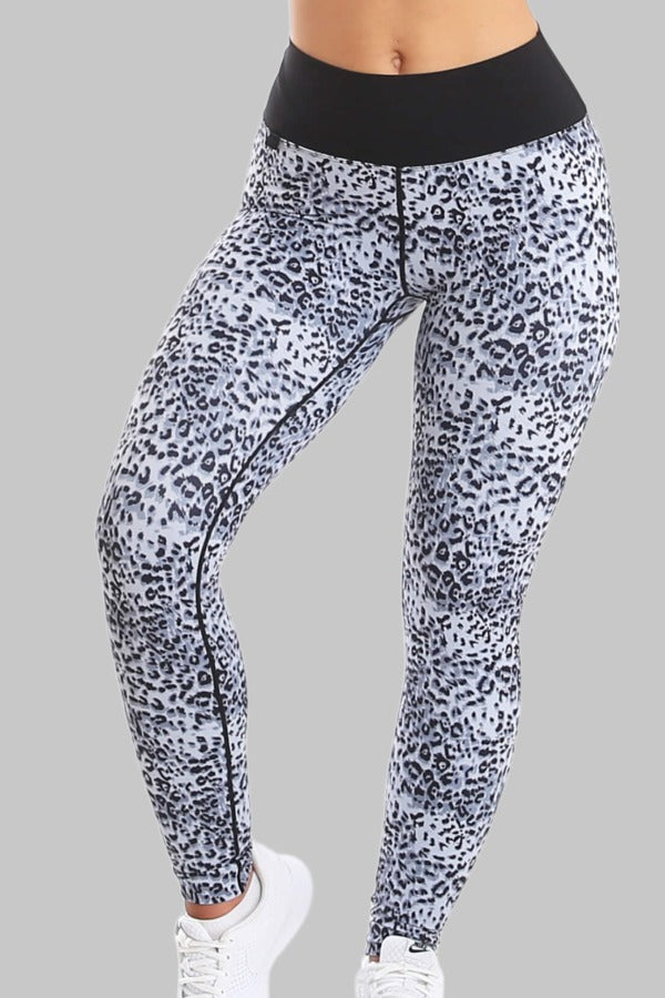 De legging heeft een zwart-grijs vlekkenmotief over het hele been en een brede zwarte tailleband.