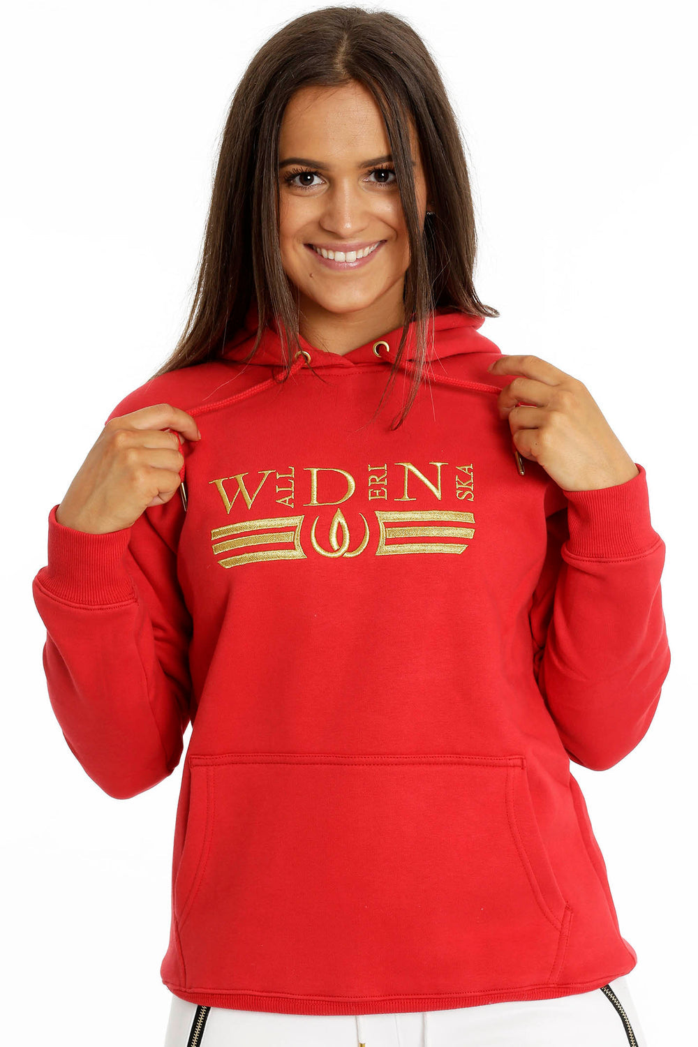 De koorden van de capuchon worden in de hand gehouden. Het gouden borduursel loopt over de borst van de rode hoodie.