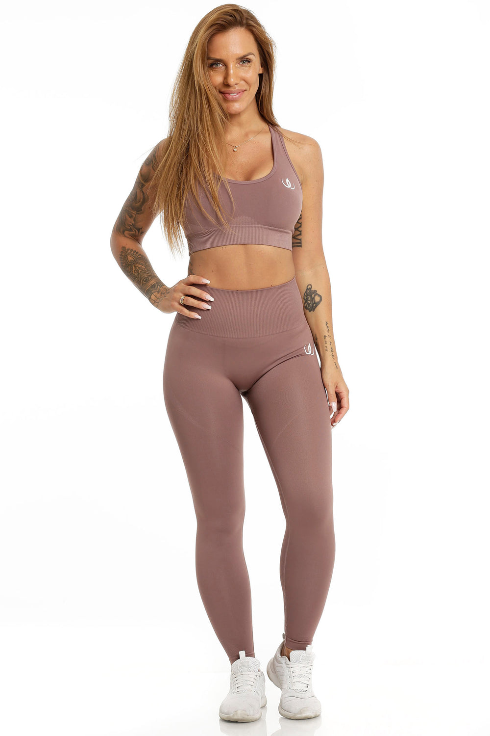 De legging loopt helemaal tot de enkel en wordt gedragen bij een bijpassende sportbeha in dezelfde tint.
